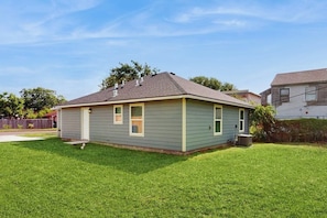 A single-story house with a sloped roof, a front porch, and a well-maintained lawn. - Emerald Escape - Steps to the Sand, Near Downtown (Corpus Christi)