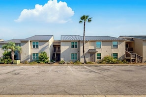 A row of two-story buildings with a parking lot in front. - Beachaholic - Bay Views, Pool, Near the Beach (Rockport)