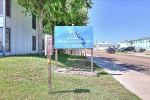 A sign for Mustang Isle Condominiums at 2025 S. 11th street. - Beach Bum - Beach Gear, 2 Blocks to Shore (Port Aransas)