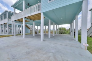 A covered outdoor area with a wooden deck, white columns, and a private driveway sign. - Sea La Vie on Paradise (Rockport)