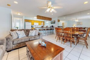 A spacious living area with a sofa, coffee table, dining table, and chairs. - Casa de la Isla/Mars Island Unit A (South Padre Island)