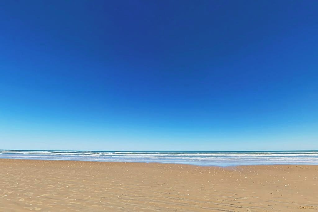 A beach with clear skies and calm water.