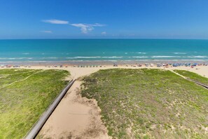 A beach with a clear view of the ocean, a sandy shore, and a grassy area. - Ocean Vista Condominiums #1004 (South Padre Island)