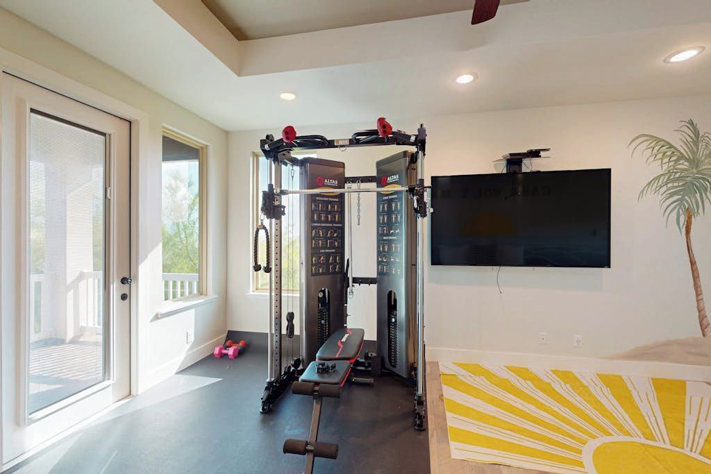 A home gym with a pull-up bar, weight bench, and various exercise equipment.
