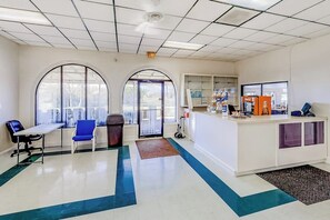 A reception area with a counter, seating, and a view through the windows. - Long Island Village 349 Sand Dollar (Port Isabel)