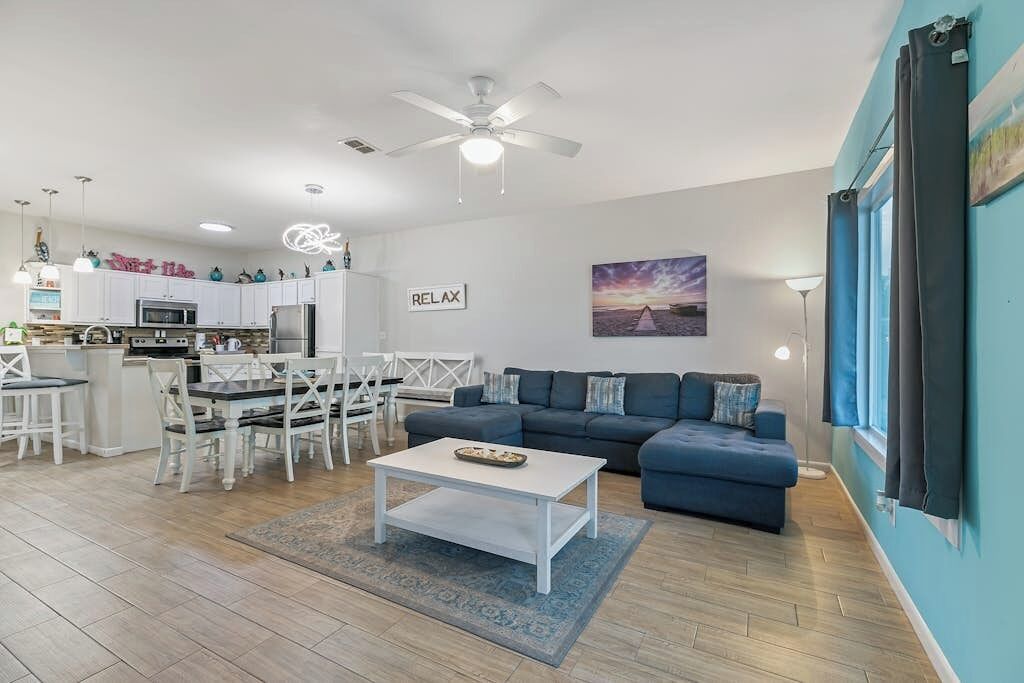 A modern living space with a kitchen, dining area, and seating area.