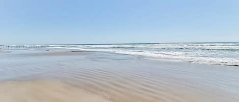 A beach with a clear sky and gentle waves.