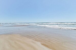 A beach with a clear sky and gentle waves. - Beach Club - Seas the Day (Corpus Christi)