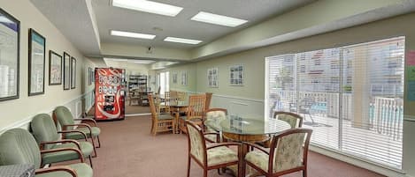 A hotel lobby with a reception desk, seating area, and large windows.