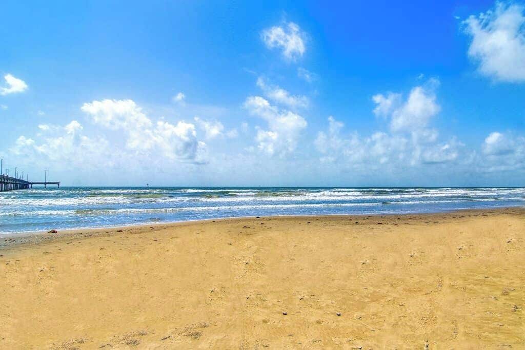 A beach with a pier extending into the water.