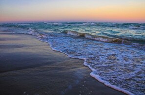 Een strand met golven die de kust naderen.