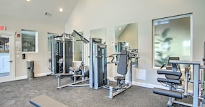 A gym with various exercise equipment, a bench, and a trash can. - Family-Friendly Beach Base with Pool and Shuttle (Ocean View)