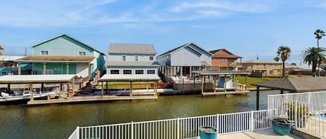A waterfront property with a swimming pool, docked boats, and a marina.