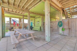 A covered outdoor area with a picnic table, wooden fence, and a sign that reads 'BEACH STUFF'. - Gulf Breezes Unit A - Gulf Views & Pool, Dogs OK (Port Aransas)
