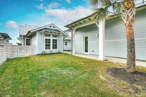 A residential property with a well-maintained lawn, a single-story house with a garage, and a palm tree. - Reserve at St Charles Bay - Cottage By The Sea (Rockport)