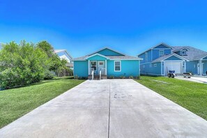 A residential property with a front driveway, a single-story house, and a garage. - The Cottage on Salt Lake (Rockport)