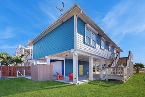 A two-story house with a covered patio area, a visible garage, and a fenced backyard. - Bay View Breeze - Bay Views & Furnished Deck (Rockport)