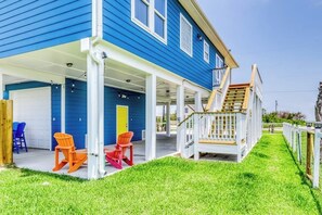 A blue house with a covered porch, a wooden staircase, and outdoor seating. - Bay View Breeze - Bay Views & Furnished Deck (Rockport)