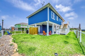 Une maison à deux étages avec un porche couvert et une cour arrière clôturée.