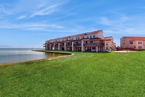 A hotel with multiple balconies, a pool, and a view of the water. - Baydreaming - Bay Views, Pool & Boat Slip (Rockport)