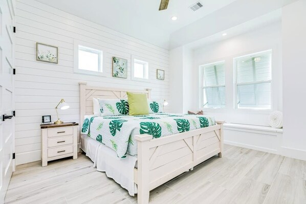A bedroom with a bed, bedside tables, a window, and a view of the outdoors. - The Blue Pelican - Bay Views and 3 Decks (Galveston)