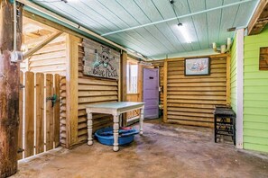 A rustic wooden interior with a table, a bench, and a door. - The Treehouse - Steps to the Beach & Sunny Deck (Galveston)
