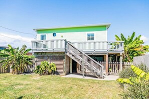 Ein zweistöckiges Haus mit Balkon, Garage und einer Treppe, die zum oberen Stock führt.