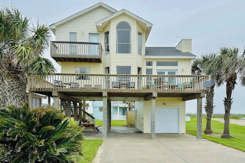A two-story house with a balcony, a garage, and a covered walkway.