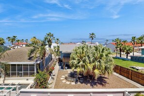 A residential area with multiple houses, palm trees, and a clear sky. - Pura Vida Unit A - Private Pool, Sleeps 13 (South Padre Island)