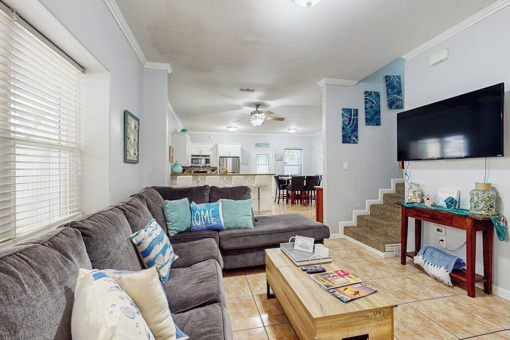 A living room with a sectional sofa, a coffee table, and a flat-screen TV.