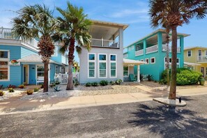 Une propriété située en bord de mer, comprenant des bâtiments à plusieurs étages, un balcon et un petit jardin.