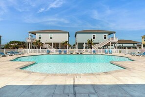 A swimming pool with a 6-inch depth marker, surrounded by lounge chairs and a white fence. - Salty Soles - Shared Pool, Patio & BBQ (Rockport)
