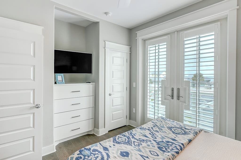 Un dormitorio con cama, armario y televisor integrado.
