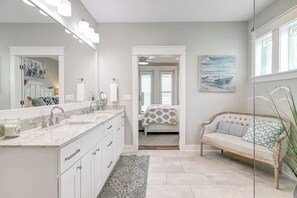 A bathroom with a large mirror, a vanity with a countertop, and a shower area. - Waterfront Paradise | Private Pool & Dock, Poolside TV & Multi-TV Game Room (Rockport)