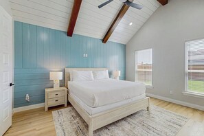 A bedroom with a bed, bedside tables, and a ceiling fan. - Roman Empire - Fenced Yard & Patio Near the Bay (Corpus Christi)