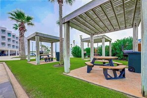 Un espace extérieur aménagé avec des tables de pique-nique et des sièges abrités.