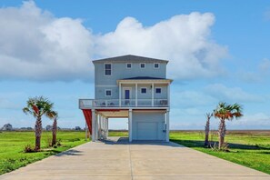 A two-story house with a covered garage and a balcony. - Sunset Bay - Bay Views, 2 Balconies, Sleeps 12 (Galveston)