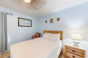 A bedroom with a bed, a nightstand, a lamp, a chair, a picture on the wall, and a curtain. - Continental #201 - Gulf-Front with Beach Access (South Padre Island)