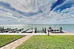 A marina with a dock, a small boat, and a grassy area. - La Solana Condominiums #111 (South Padre Island)
