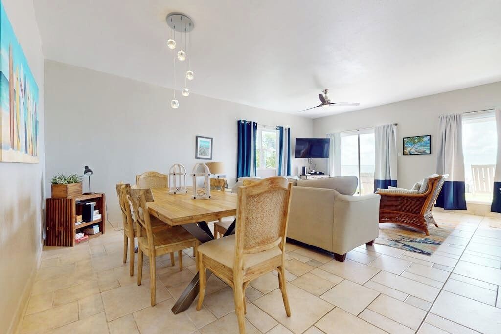 Amplia sala de estar con mesa de comedor, sillas, sofá y televisor.