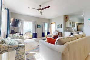 A living room with a sofa, a chair, a ceiling fan, and a view of the outside. - La Solana Condominiums #111 (South Padre Island)