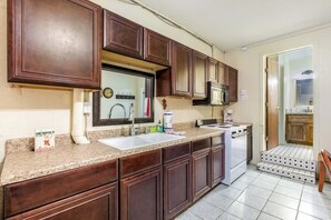 Una cucina con mobili scuri in legno, un piano cottura bianco e un lavello a due vasche.