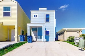 A residential street with houses, a clear sky, and a sidewalk. - Las Joyas Bayview Home #202 (Port Isabel)