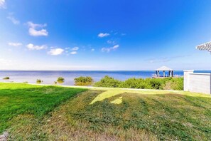 A grassy area with a gazebo overlooking a body of water. - Las Joyas Bayview Home #202 (Port Isabel)