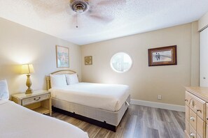 A bedroom with a bed, bedside tables, a dresser, and a ceiling fan. - Solare Garden Villa 771F (South Padre Island)