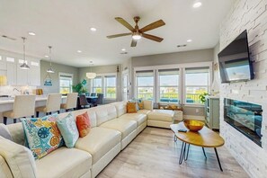 Una sala de estar moderna con un sofá modular, un comedor y una cocina.