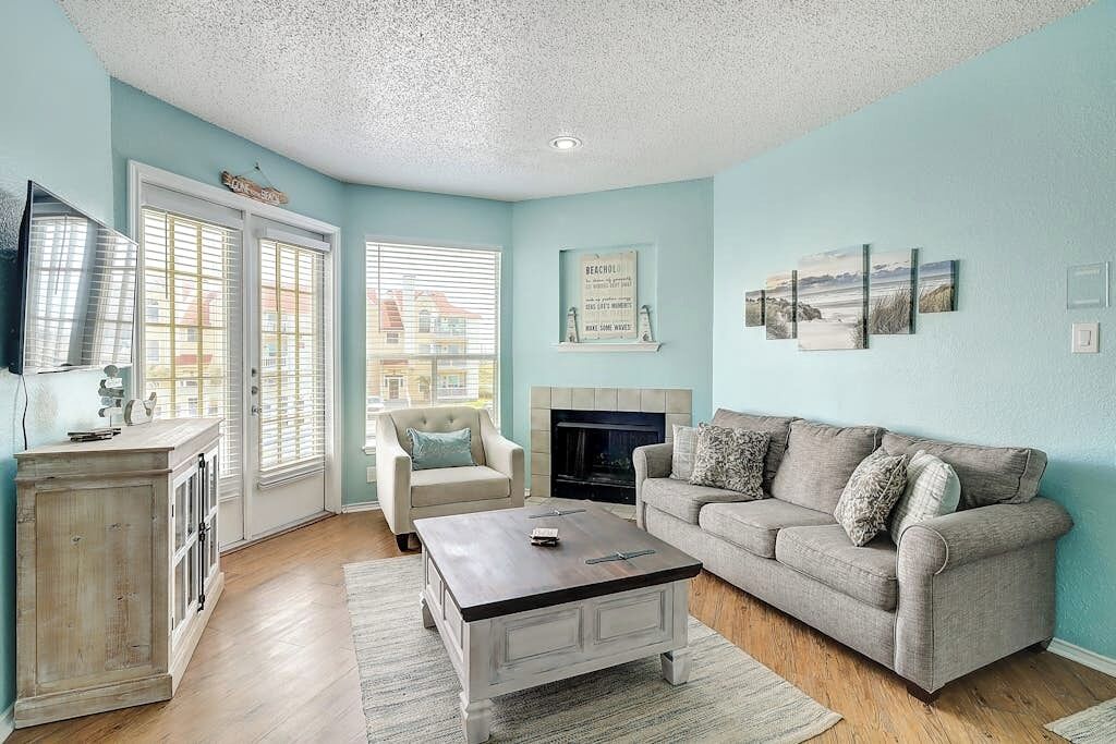A living room with a fireplace, a sofa, a coffee table, and a television.