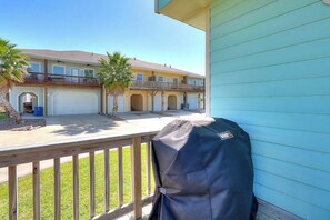A residential building with a covered porch, a garage, and a balcony with a barbecue grill. - Beachy Keen - Dog-Friendly with Shared Pool (Port Aransas)