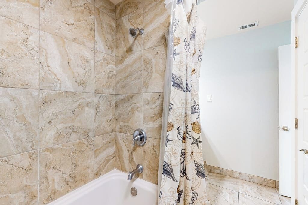 Ein Badezimmer mit Dusche, Badewanne und einer Tür.