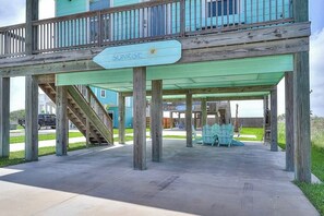 A wooden deck with a sign reading 'SUNRISE' and a covered area with chairs. - Eskridge Gem Unit B - Near Shops & Beach, Dogs OK (Port Aransas)